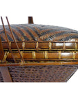 Close-up of a brown and black hand woven rattan basket with intricate zigzag patterns.
