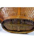 Close-up of brown rattan and wood woven basket bottom with cross supports, showing texture and construction.