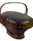 Brown rattan basket with handle and lid, close-up showing intricate geometric patterns, very good condition.