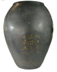 Tall dark ceramic vase with gold Chinese calligraphy and subtle cracquelure, shown against a neutral background.