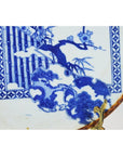 Blue and white ceramic Igezara transferware plate with ridged iron-brown edge and floral, geometric patterns, close-up.