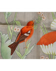 Red-orange bird with light paint loss on a branch with flowers, India silk tapestry background.