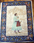 Blue and gold silk tapestry featuring Mughal-style nobleman with ornate floral border, in very good condition.