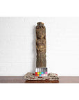 Colorful polychrome hand-carved wood statue of Indian celestial musician, shown with color chart by white brick wall.