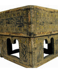Brown carved wood betel nut box with animal designs and arched window openings, close-up.