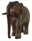 Brown wood Indian elephant carving with tusks and saddle, good condition, standing on all four legs.