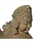 Close-up of gray stone Indian sphinx sculpture with tiara and earrings, hand-carved, 19th century, facing right.