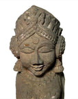 Gray hand-carved stone sphinx sculpture with tiara and earrings, 19th c. Indian, on a white background.