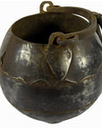 Close-up of a rustic iron Indian water jug with handle, vintage style, used as vase for home decor.