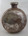 Rustic metal oval-shaped Indian water jug with short neck and cap, close-up on plain white background.