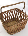 Square silver nickel wire woven basket with arched handle on a light background.