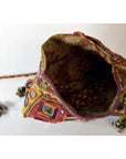Multicolored embroidered fabric pouch with geometric patterns and mirrors, drawstring closure, top view.