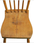 Close-up of a worn wood Indonesian chair seat with visible spindles and scratches on a white background.