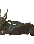 Close-up of dark brown, green, and blue Indonesian deer wall plaque with hand carved antlers and detailed face.