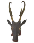 Brown Indonesian deer wall trophy with hand carved antlers, long curved horns, and large round eyes on white background.