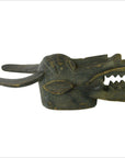 Dark wood hand-carved Indonesian figural shield with long horns, pointed ears, open mouth, visible cracks and repairs.