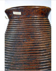 Brown ceramic ridged pottery vase from Lombka Island with small white label near rim, close-up view.