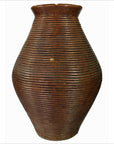 Large brown ceramic vase with ribbed texture and flared rim, close-up on white background.