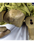 Close-up of Indonesian puppet with movable joints, loose leg, green and blue fabric clothing.
