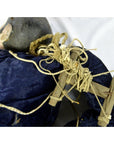 Close-up of blue fabric Indonesian puppet with tangled strings and one loose leg on white background.