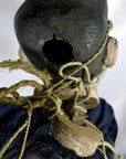 Brown wooden Indonesian puppet with tangled strings, one loose leg, ropes around neck and shoulders, rear view.