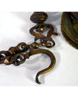 Close-up of vintage brass Japanese temple incense burner hook and chain with decorative detailing.