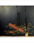 Black lacquered wall panel with Japanese calligraphy, red airplane in green smoke, repaired vertical crack visible.