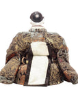 Close-up of Japanese doll in colorful patterned silk robe with large obi, rear view on white background.