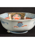 Close-up of a hexagonal Japanese Imari porcelain bowl with blue, red, and gold floral and geometric patterns.