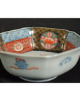 Colorful porcelain Imari bowl with octagonal shape, floral and geometric patterns inside and outside, close-up view.