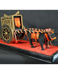 Close-up of a red and black lacquered Japanese festival carts model with ornate decorative details on base.