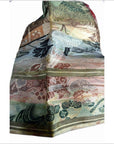 Close-up of Japanese silk sash with muted green, beige, and pink floral and geometric patterns.
