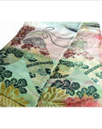 Close-up of green, yellow, and red floral and leaf patterns on Japanese silk sash, 11.5 inches wide.