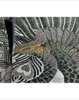 Close-up of green, gray, and gold embroidery with peacock feathers on Japanese silk sash.