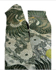Close-up of Japanese silk sash with green and gold birds, white and yellow flowers in intricate Japanese pattern.