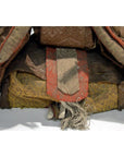 Close-up of a worn fabric bundle with frayed edges and red-brown strap from a Japanese Taisho Samurai Doll.