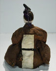 Brown fabric Japanese Taisho Samurai doll with black hat, back view, plain background.