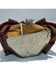 Brown, gold, and white fabric Japanese Taisho samurai doll on a plain surface.