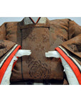 Close-up of Japanese Taisho era samurai doll in patterned antique kimono with two delicate white hands visible.