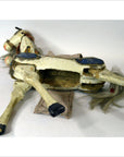 Damaged vintage two-headed horse toy, multicolored plastic, missing parts, lying on its side.