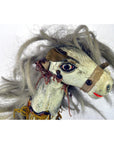 Close-up of a Japanese two-headed horse toy with tangled gray hair, painted faces, and visible neck stitching.