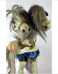 Painted two-headed horse toy with blue saddle and tangled gray manes, shown on a white background.