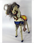 Brown two-headed horse toy with tangled mane and blue sequined saddle on white background.