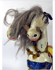 Painted wood Japanese two-headed horse toy with tangled gray mane and faded decorations, wear visible, plain background.