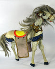 Close-up of a vintage Japanese two-headed horse toy with painted body and colorful fabric saddle and blanket.