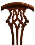 Close-up of brown lacquered wood Javanese swivel desk chair back with intricate ornate carving.