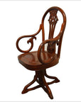 Brown wood swivel desk chair with curved arms and carved backrest, four-legged base, indoor setting.