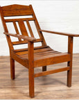 Brown wooden lounge chair with slanted back on wood floor.