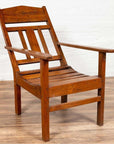 Brown wooden lounge chair with slanted back on wood floor.