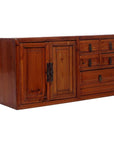 Brown wood jewelry box with double left doors and five assorted-size right drawers, close-up.